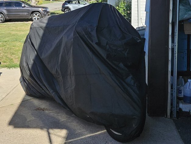 a motorbike under a cover for how to fold a motorcycle cover