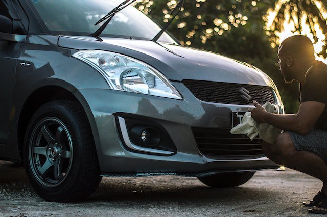 a man cleaning a car for how to put car cover on suv